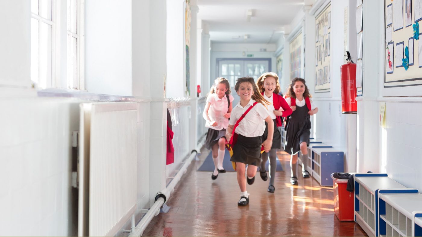 Children running down school corridor